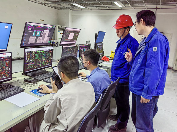 5月13日，動(dòng)力車間三期鍋爐控制室，DCS改造工藝、儀表、電氣等部門聯(lián)合調(diào)試，車間主任姜軍虎與技術(shù)員畢加佳查看調(diào)試過(guò)程.jpg