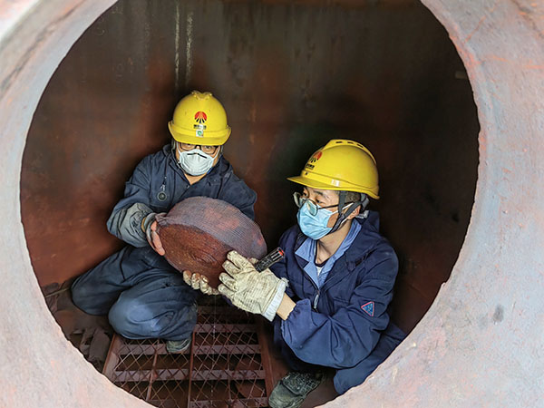 5月11日，動(dòng)力車間三期工藝除氧器內(nèi)部，黨員突擊隊(duì)隊(duì)員劉瑞斌和李震正在清理舊填料.jpg
